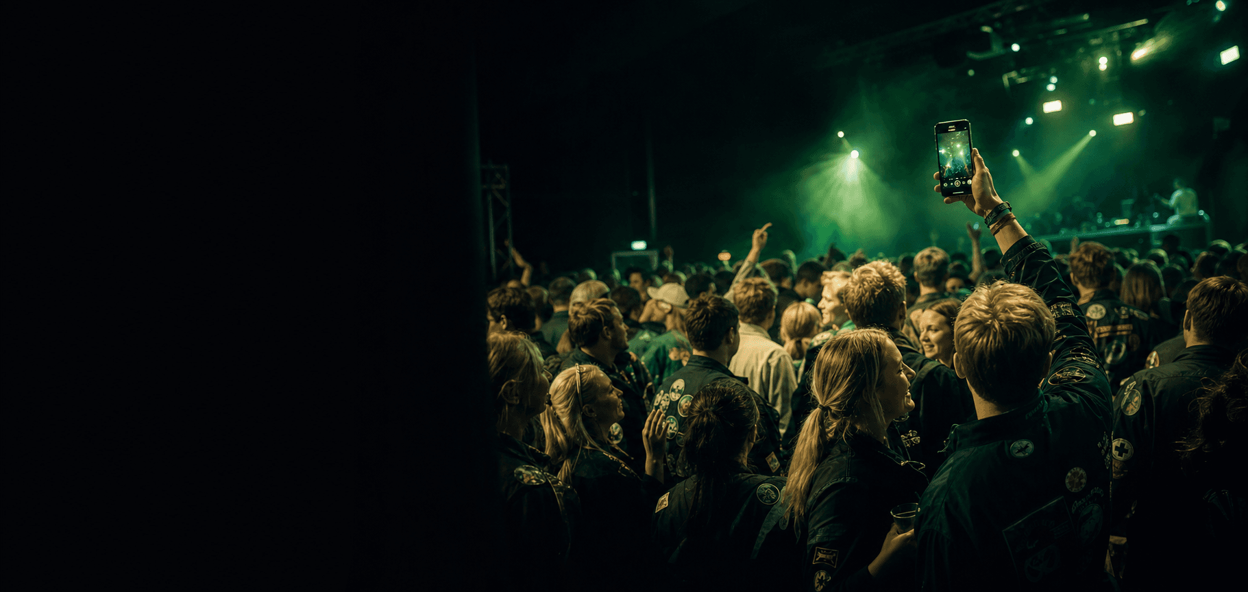 Students celebrating at a Finnish student event night with lime and teal lighting.