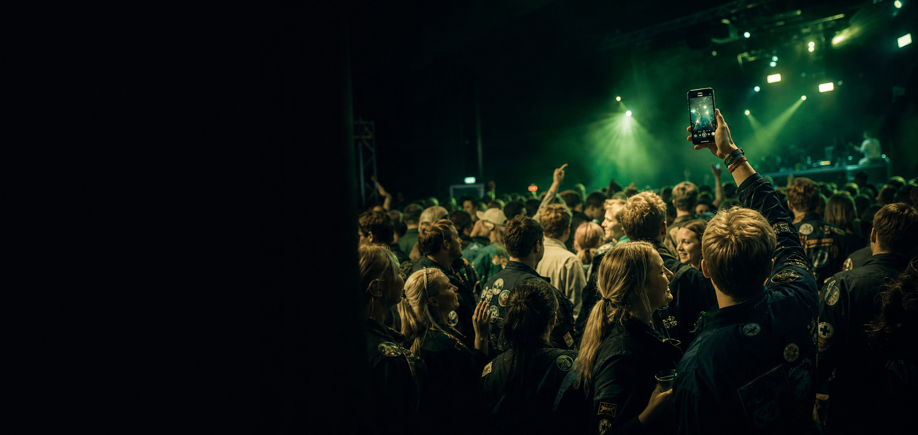 Students celebrating at a Finnish student event night with lime and teal lighting.